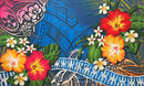 A flat-lay view of the Hibiscus, Plumeria Assortment Sarong (Style 2) featuring a vibrant Polynesian-inspired design. The pattern includes large red and orange hibiscus flowers with yellow centers, mixed with white plumeria blossoms. The background is a rich blue with layered traditional tribal motifs, including intricate black tattoo patterns, stylized green monstera leaves, and a decorative white geometric border at the bottom.