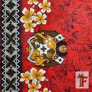 A close-up of a red tropical fabric featuring a floral and leaf pattern, a central crest, and a black, white, and red geometric border on the left.
