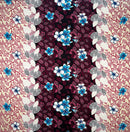 A piece of rayon fabric featuring a Plumeria flowers and leaves pattern with a symmetrical design in a combination of beige, brown, cream, and blue colors.